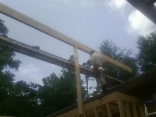 Carpenter setting a ridge beam over a new addition frame — Ice Dam Removal by Roofing Brothers in Ordway