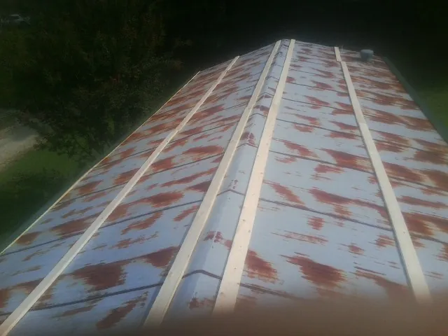 Rusted metal roof panels with new wood purlins before replacement — Storm Damage Roof Repair in Ordway by Roofing Brothers