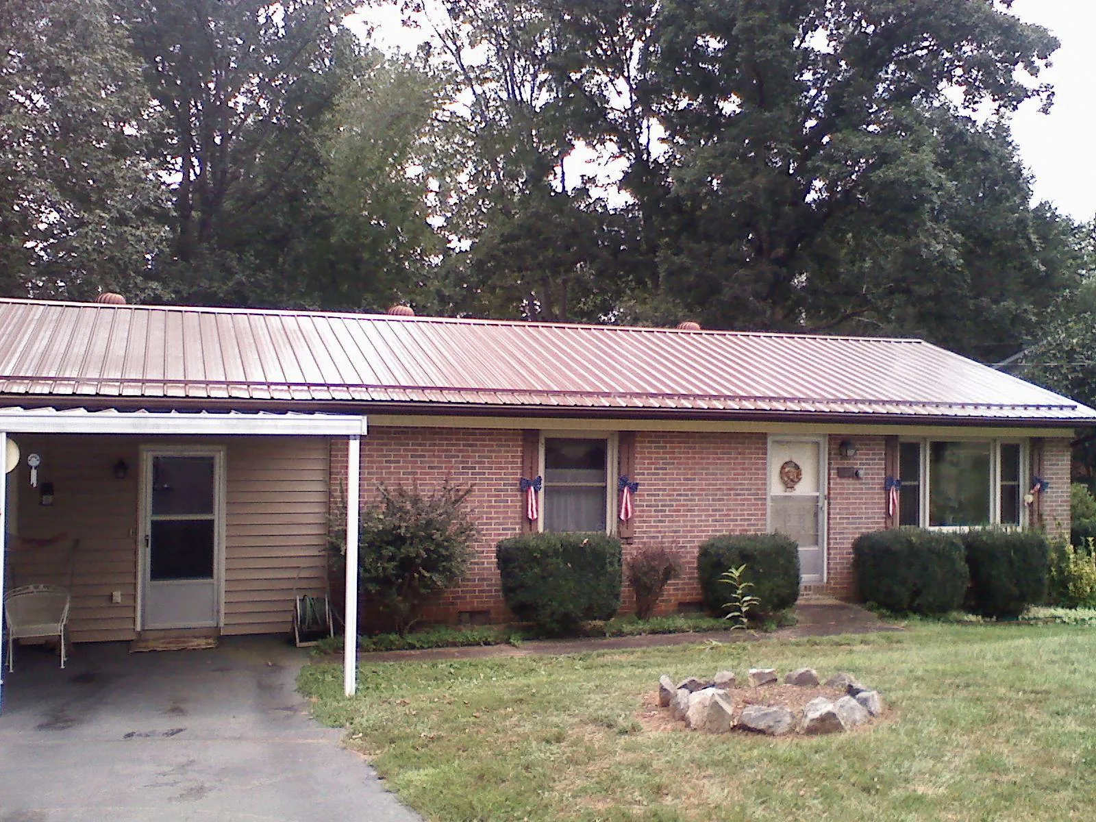 Bronze metal roof and carport on a brick ranch home — Roof Repair work by our crew in Ordway